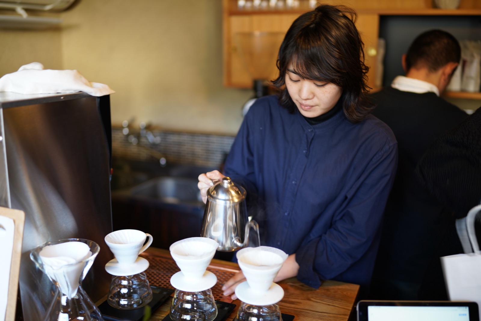 A barista making pour-over coffee at a Kyoto cafe, photographed by Lee Hnetinka